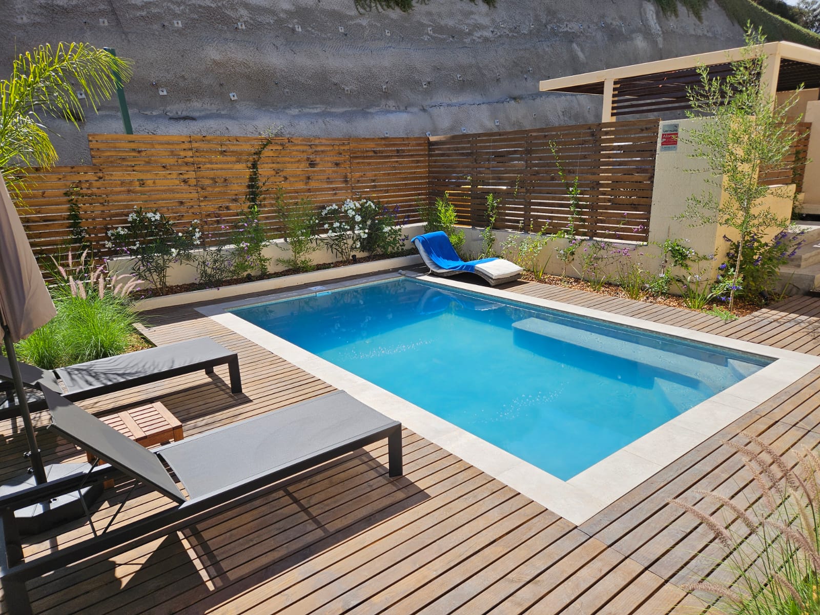 Piscina AcuaNova Las Condes con deck de madera y diseño moderno